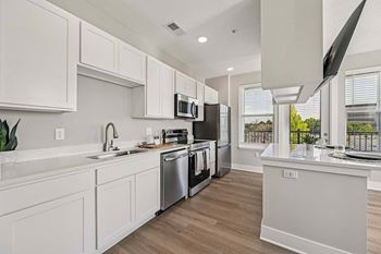 A modern kitchen with white cabinets and stainless steel appliances.